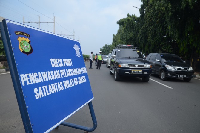 Petugas Kepolisian yang di bantu petugas Dinas Perhubungan saat memberikan himbauan pada pengendara di Jalan TB Simatupang, Jakarta, Senin (13/4/2020). Dalam rangka percepatan penanganan COVID-19, Pemprov DKI Jakarta memberlakukan Pembatasan Sosial Berska - Image