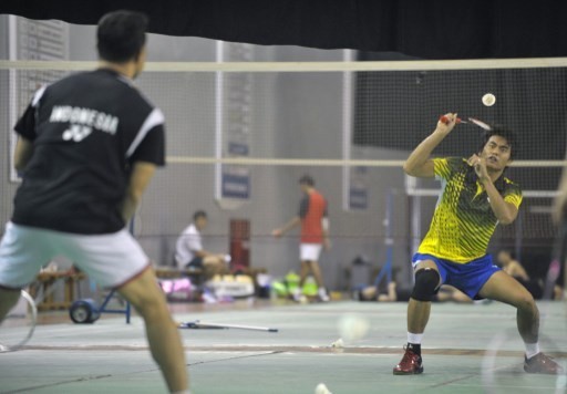 Mixed doubles badminton player Tantowi Ahmad (R) of Indonesia practices with his coach Richard Mainaky in Jakarta on September 2, 2014, in preparation for the 17th Asian Games in Incheon from September 19 to October 4. Indonesia is targeting their medal h - Image