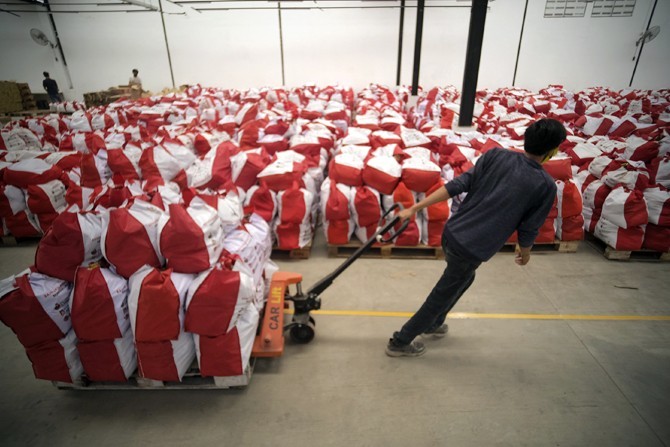 Petugas melakukan paking sembako yang akan di kirim ke lokasi rumah terdampak Covid-19 di Kota Tangerang, Banten, Indonesia, Minggu (10/5/2020). Sebanyak 55.066 paket sembako dari Presiden siap didistribusikan kepada masyarakat kurang mampu di Kota Tanger - Image