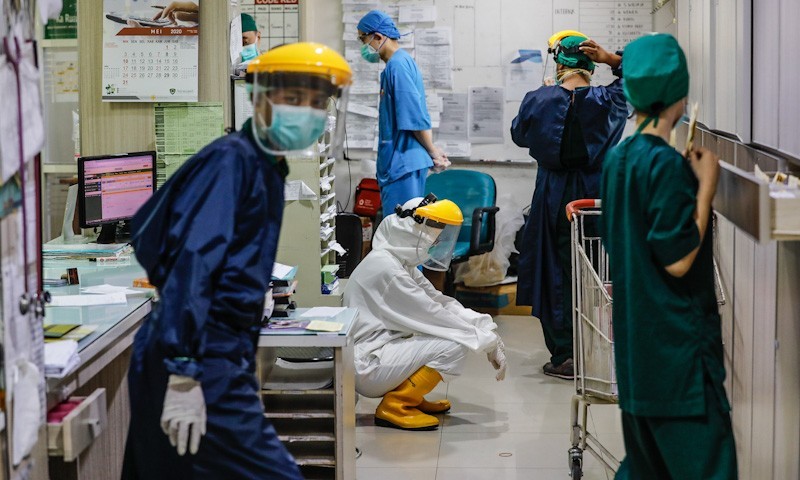 Dr Vivi Silvia salah satu tenaga medis yang menangani pasien Covid-19 tertunduk lesu dikarenakan banyaknya pasien yang ditangani serta gerah menggunakan hazmat berjam jam di RS Adi Husada Surabaya, kemarin, Rabu (27/5/2020).Foto:Dipta Wahyu/Jawa Pos - Image