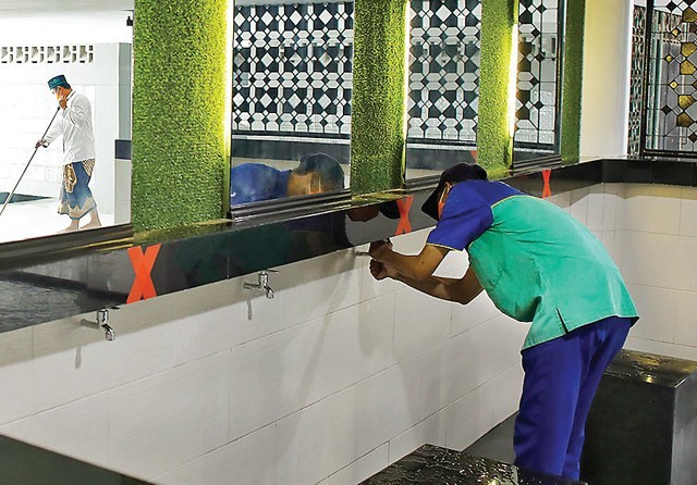 ADA SPOT SELFIE JUGA: Pekerja membersihkan salah satu toilet di Masjid Al Akbar yang direhab modern. (Dipta Wahyu/Jawa Pos) - Image