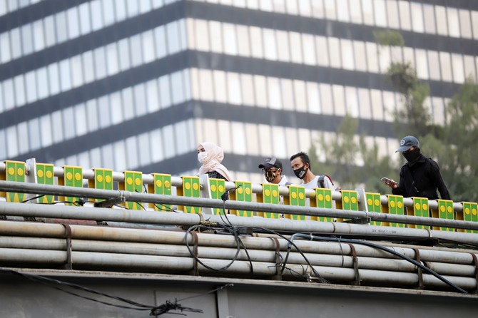 Lalu lalang para pekerja pada jam sibuk di kawasan Jalan Sudirman, Jumat (13/6/2020). Kementerian Ketenagakerjaan meminta para pengusaha merekrut kembali pekerja atau buruh yang terkena PHK dan dirumahkan akibat pandemi COVID-19. Langkah ini diharapkan da - Image