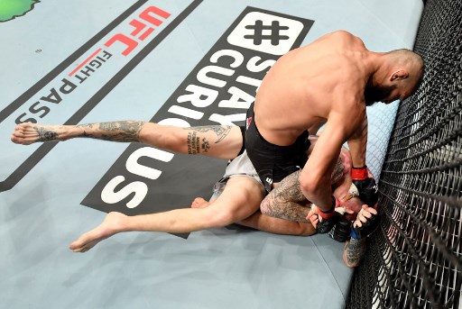 In this handout image released by the Ultimate Fighting Championship (UFC), Khamzat Chimaev of Czechia (L) punches Rhys McKee of Northern Ireland in their welterweight fight during the UFC 251 event at UFC Fight Island in Abu Dhabi - Image