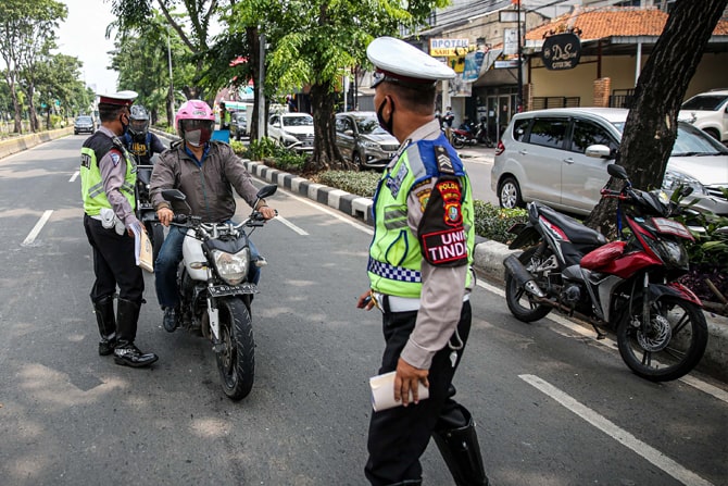 Polisi Lalu lintas menilang pengendara sepeda motor yang melintas di Jalan Letjen Suprapto, Jakarta, Kamis (23/7/2020). Ditlantas Polda Metro Jaya menggelar Operasi Patuh Jaya dari 23 Juli sampai 5 Agustus untuk menertibkan masyarakat dalam berlalu lintas - Image