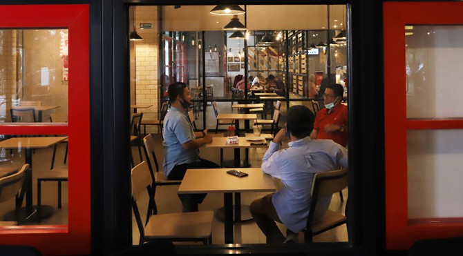 Pelayan menggunakan alat pelindung diri wajah, masker dan sarung tangan saat melayani pelanggan Food Court Funtastico Bintaro, Tangerang Selatan, Banten, Jumat (10/7/2020). Sejumlah restoran dan tempat makan salah satunya Funtastico Bintaro menerapkan men - Image