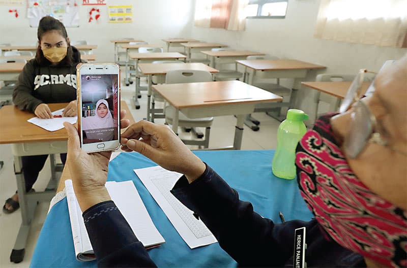 TATAP LAYAR: Guru SDN Rawa Badak Selatan 1 Jakarta, memperkenalkan ruangan sekolah kepada siswa secara daring, Selasa (14/7). (FEDRIK TARIGAN/JAWA POS) - Image