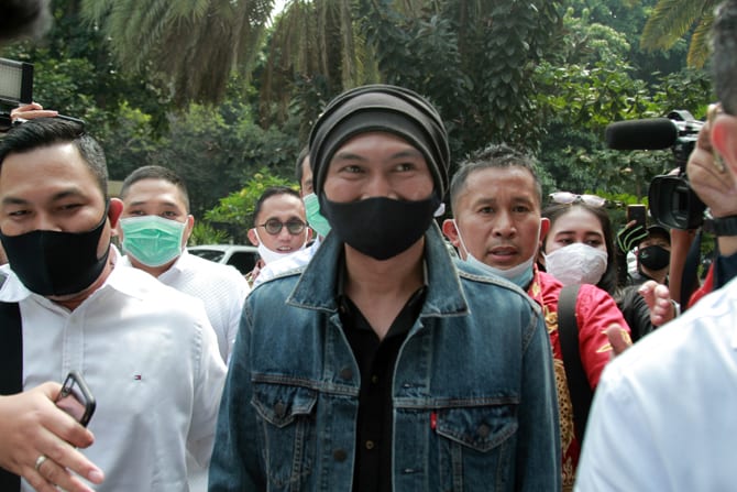 Erdian Aji Prihartanto alias Anji (tutup kepala hitam) saat datang di Mapolda Metro Jaya, Senin (10/8/2020). Penyidik Sub Direktorat Kejahatan Siber Direktorat Reserse Kriminal Khusus Polda Metro Jaya, memeriksa pemilik akun youtube @duniamanji, Anji seba - Image