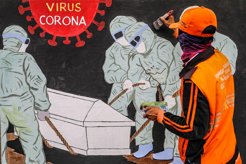 Petugas PPSU Kelurahan Bukit Duri menyelesikan mural Covid-19 di Jakarta, Senin (10/8/2020).Mural tersebut memperlihatkan petugas medis membawa sebuah peti yang mengingatkan warga agar selalu waspada dengan Covid-19 dan mencegahnya dengan 3 M (Memakai Ma - Image