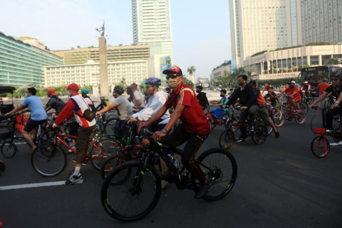 Warga bersepeda melintas di kawasan MH Thamrin, Jakarta, Minggu (2/8/2020). Warga tetap berolahraga di tempat umum meski PSBB masa transisi fase pertama untuk ketiga kalinya diperpanjang hingga 13 Agustus 2020 akibat tren penambahan kasus positif COVID-19 - Image
