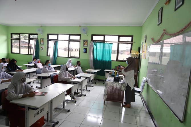 Guru memberikan materi saat kegiatan belajar mengajar Di SMP Negeri 2, Bekasi, Jawa Barat, Selasa (4/8/2020). Pemkot Bekasi memberikan izin kepada enam sekolah untuk melakukan uji coba pembelajaran tatap muka selama satu bulan. Enam sekolah yang sudah mul - Image