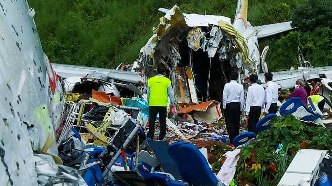 EVAKUASI: Petugas memeriksa kondisi pesawat Air India Express yang terbelah dua setelah jatuh di Bandara Internasional Calicut, Kerala, India. (AFP via Channel News Asia) - Image