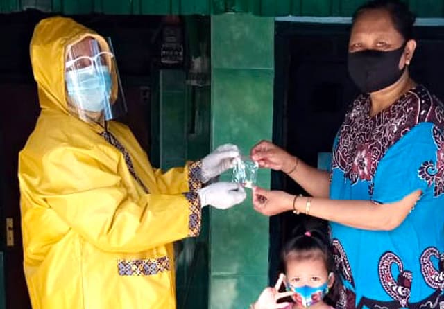 BLUSUKAN: Petugas memberikan vitamin untuk anak kepada ibu yang memiliki balita. (Dinkes Surabaya for Jawa Pos) - Image