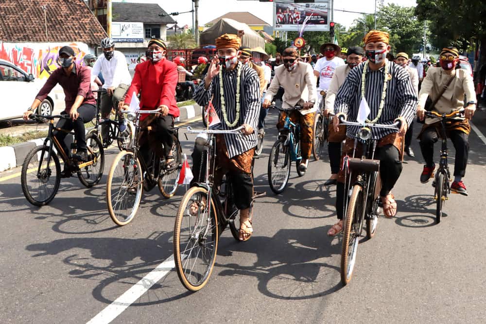 SOLID: Gibran dan Teguh naik sepeda onthel saat hendak mendaftar sebagai cawali-cawawali Solo. (DAMIANUS BRAM JAWA POS) - Image