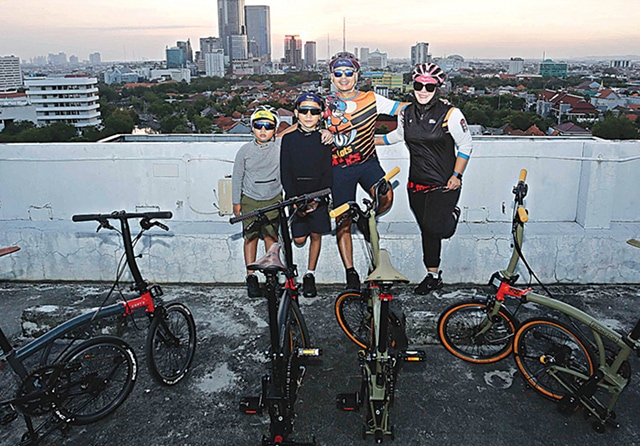 MATCHING BROMPTON: Rully beserta keluarga kecilnya berfoto di rooftop Mal Grand City Kamis (10/9). (Guslan Gumilang/Jawa Pos) - Image