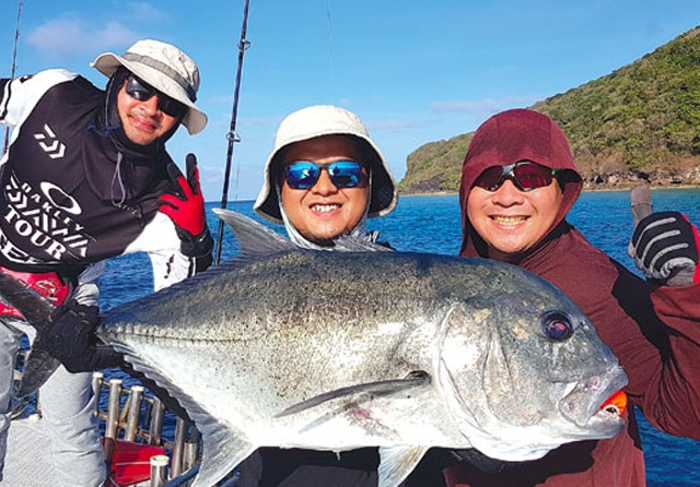 VIEW INDAH: Angga (tengah) bersama dua rekannya, Theofilus (kiri) dan Budi Kang saat memancing di Pulau Romang, Maluku Barat Daya. Hobi itu dia jalani sejak tujuh tahun lalu. (Anggara Yuniarto for Jawa Pos) - Image