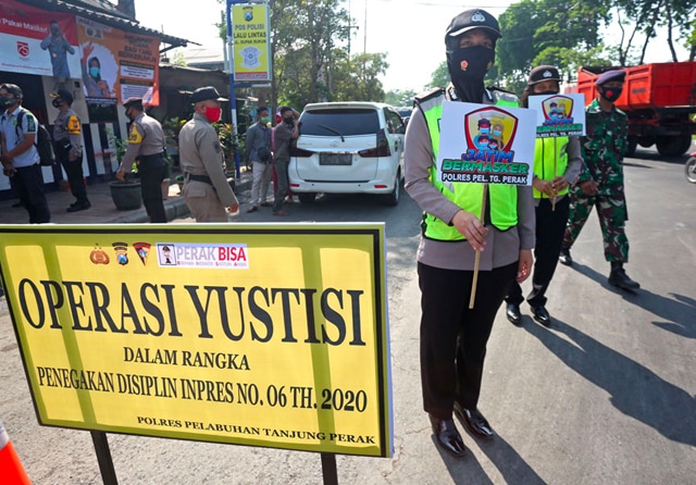 RAZIA GABUNGAN: Aparat olres Pelabuhan Tanjung Perak dan Satpol PP mengadakan operasi yustisi penegakan protokol kesehatan. (Dipta Wahyu/Jawa Pos) - Image