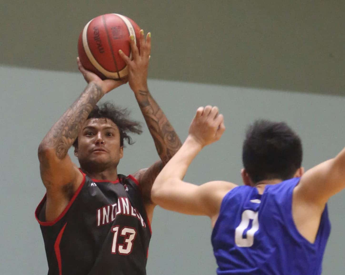 Pemain Indonesia Patriots (Timnas Indonesia), Brandon Jawato berusaha melakukan shooting dibayangi pemain Satria Muda Pertamina, saat pertandingan uji coba di GBK Arena Senayan, Jumat 3/1/20. Timnas Indonesia menang dengan skor 69-64. Uji coba ini sebagai - Image
