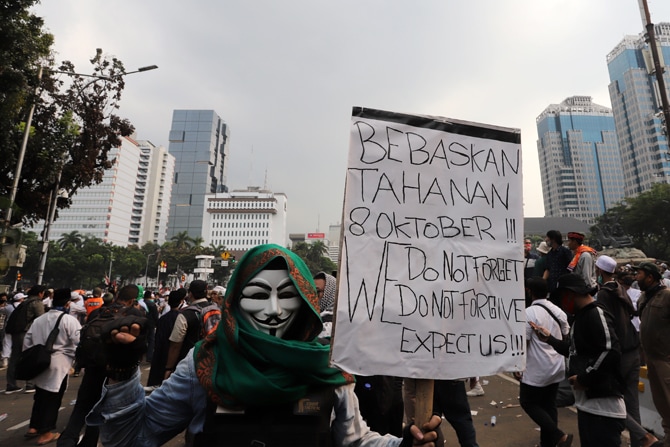 Massa pengunjuk rasa membawa poster di Jalan Merdeka Barat, Jakarta, Selas (13/10/2020). Massa pengunjuk rasa yang menolak Omnibus Law akhirnya dibubarkan aparat. Foto: Dery Ridwansah/ JawaPos.com - Image