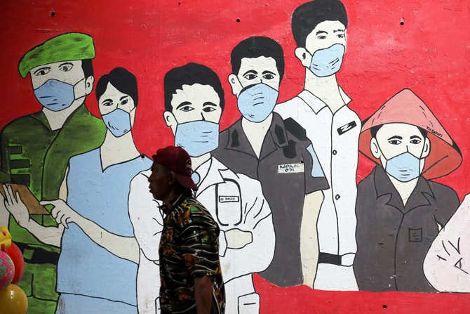 Warga melintas dengan latar belakang mural anjuran menggunakan masker di kawasan Cilangkap, Jakarta, Jumat (2/10/2020). Program gebrak masker diharapkan dapat memberi kesadaran kepada masyarakat akan pentingnya memakai masker dan mengikuti anjuran protoko - Image