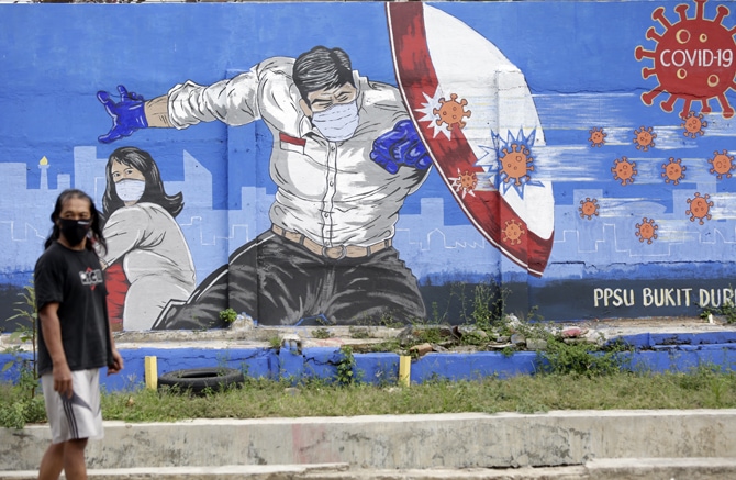 Pengguna jalan melintas di depan mural bergambarkan - Image