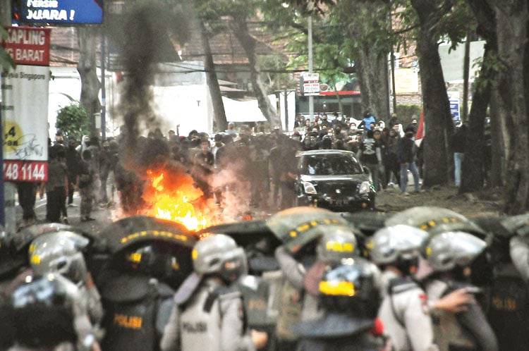 MEMANAS: Sejumlah demonstran membakar ban dalam unjuk rasa di depan gedung DPRD Jawa Barat, Bandung. (TAOFIK ACHMAD HIDAYAT/RADAR BANDUNG) - Image