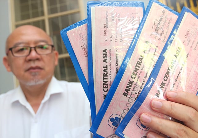 TAK BISA CAIR: R. Teguh Santoso menunjukkan bilyet deposito yang diterbitkan pada 1988 dan sampai sekarang masih dipegang kliennya. (Dimas Maulana/Jawa Pos) - Image