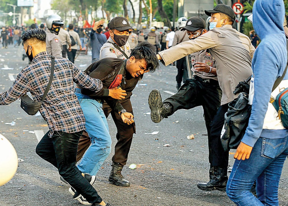BENTROK: Aparat kepolisian mengamankan seorang pendemo yang terlibat dalam kerusuhan. (DIPTA WAHYU/JAWA POS) - Image