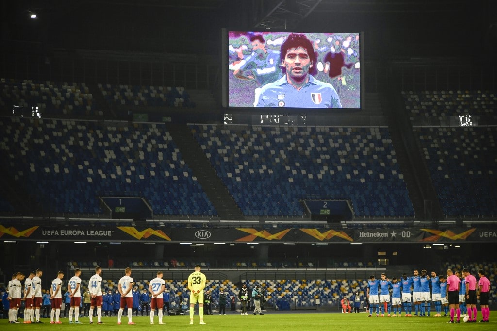 A screen displays a photo of late Argentinian football legend Diego Maradona as players hold a minute of silence in homage to Maradona prior to the UEFA Europe League Group F football match Napoli vs Rijeka on November 26, 2020 at the San Paolo stadium in - Image
