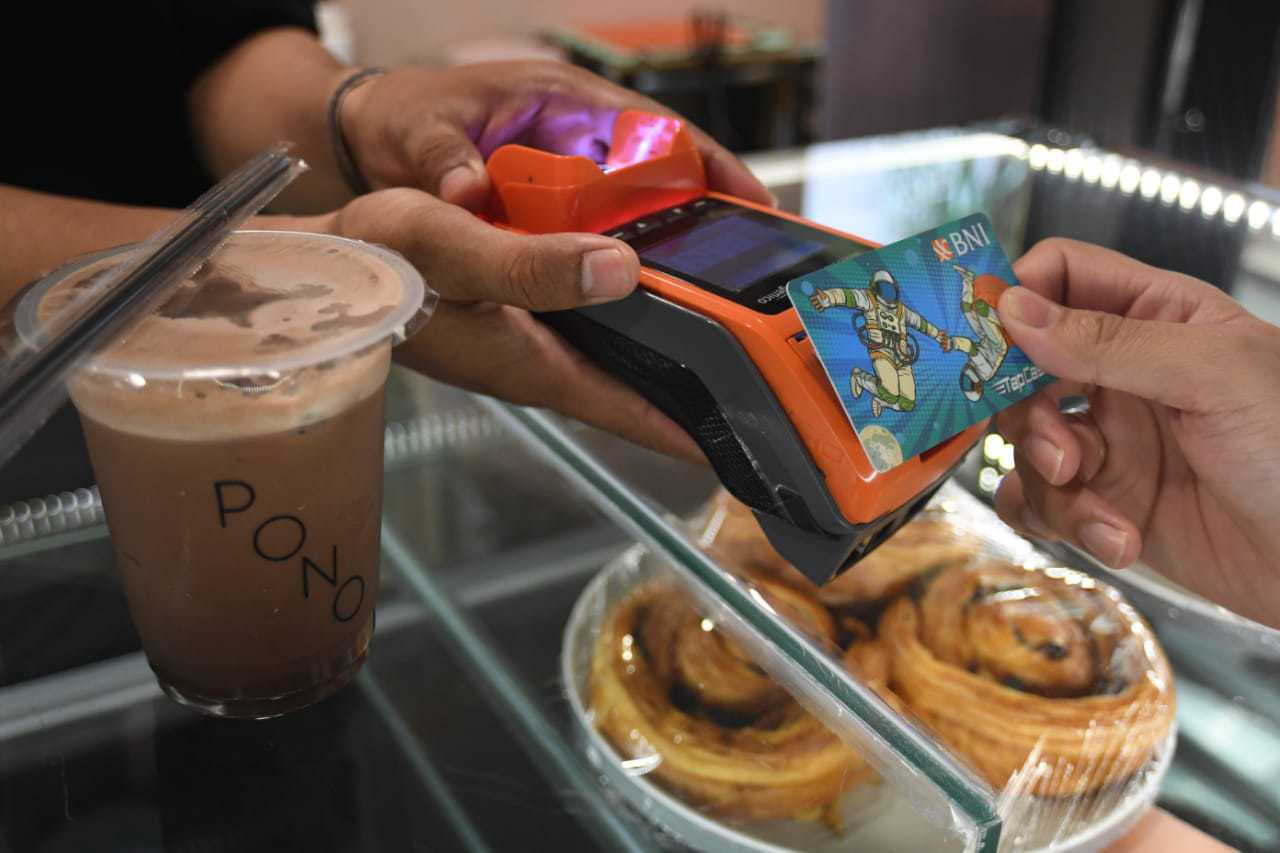 Pengunjung sebuah cafe sedang bertransaksi menggunakan kartu BNI TapCash di Jakarta, (Jumat, 20 November 2020). Untuk turut memutus mata rantai penyebaran virus Covid-19, pemerintah menghimbau masyarakat untuk menggunakan metode pembayaran cashless. Selam - Image