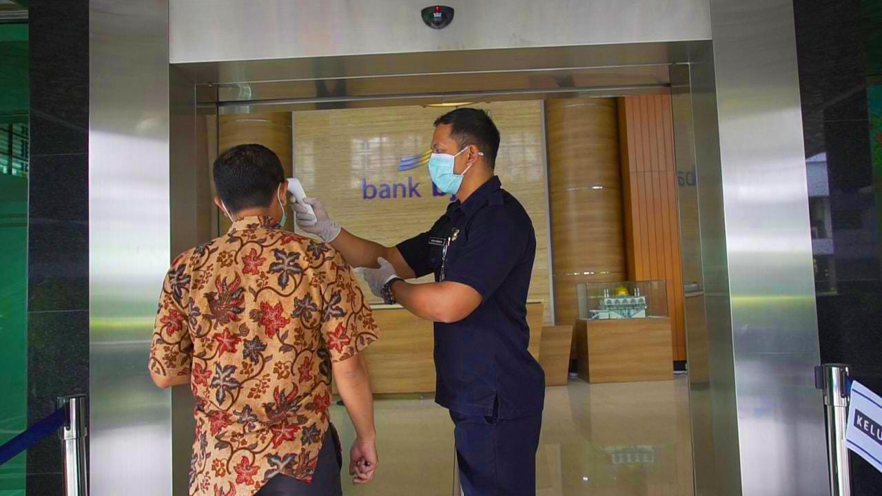 Ilustrasi pemeriksaan suhu tubuh bagi nasabah yang ingin melakukan transaksi keuangan di kantor cabang bank bjb - Image