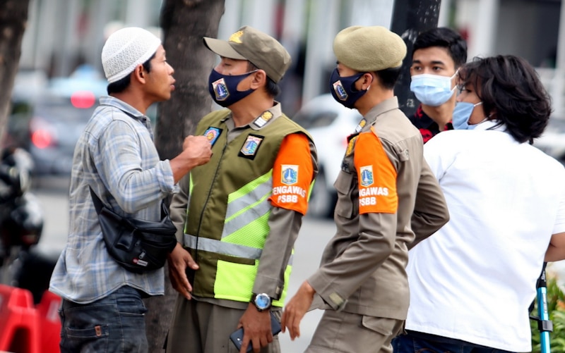 petugas satpol PP beradu mulut dengan warga saat mengingatkan untuk mengenakan masked pada saat kampanye protokol kesehatan dikawasan MH Thamrin,Jakarta, Senin (30/11). Kasus COVID-19 di Jakarta kembali meningkat sehingga kampanye protokol kesehatan kemb - Image