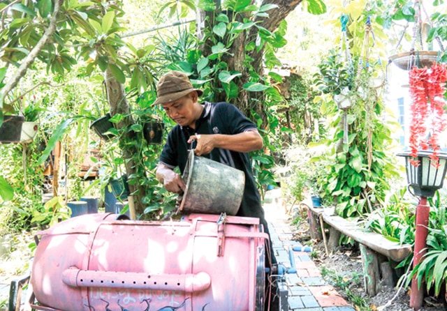 LINGKUNGAN HIJAU: Suroto membuat pupuk kompos dari limbah rumah tangga dan dedaunan. Warga sekitar boleh menyetorkan sampah organik. (Alfian Rizal/Jawa Pos) - Image