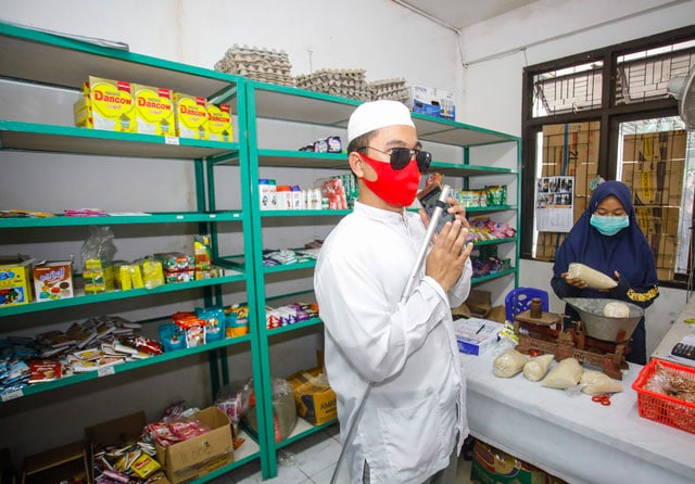 EKONOMI KERAKYATAN: Kardjono di gerai koperasi yang dirintisnya. Koperasi tersebut cukup membantu warga yang tinggal di flat. (Dipta Wahyu/Jawa Pos) - Image
