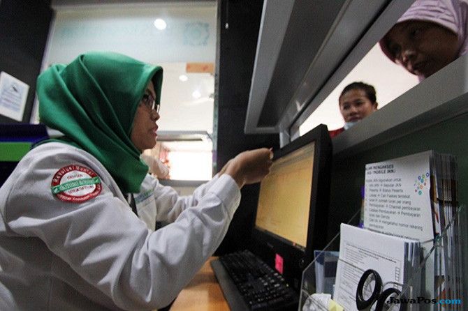 ILUSTRASI: Petugas loket BPJS Kesehatan tengah melayani anggota di kantor BPJS Jakarta, belum lama ini. - Image