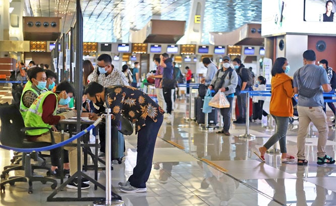 Petugas Kantor Karantina Pelabuhan (KKP) memeriksa dokumen persyaratan kesehatan penumpang di Terminal 3, Bandara Soekarno Hatta, Tangerang, Jumat (18/12/2020). Mulai hari ini (18/12) seluruh transportasi publik khususnya udara, pemerintah memberlakukan r - Image