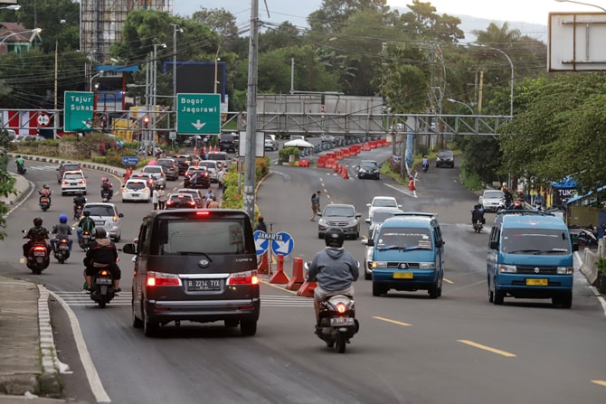 Sejumlah kendaraan melintas di lampu merah Simpang Gadog, Kabupaten Bogor, Jawa Barat, Jumat (25/12/2020). Arus lalu lintas di jalur wisata Puncak normal saat libur Natal. Foto: Dery Ridwansah/ JawaPos.com - Image