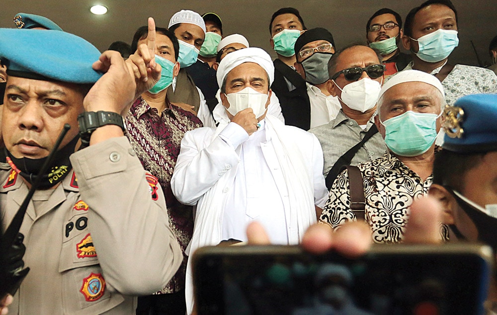 TERJERAT KERUMUNAN: Rizieq Shihab tiba di Polda Metro Jaya untuk menjalani pemeriksaan Sabtu (12/12). Itu adalah kehadirannya yang pertama setelah dua kali panggilan polisi untuk tidak dihadirinya. (SALMAN TOYIBI/JAWA POS) - Image