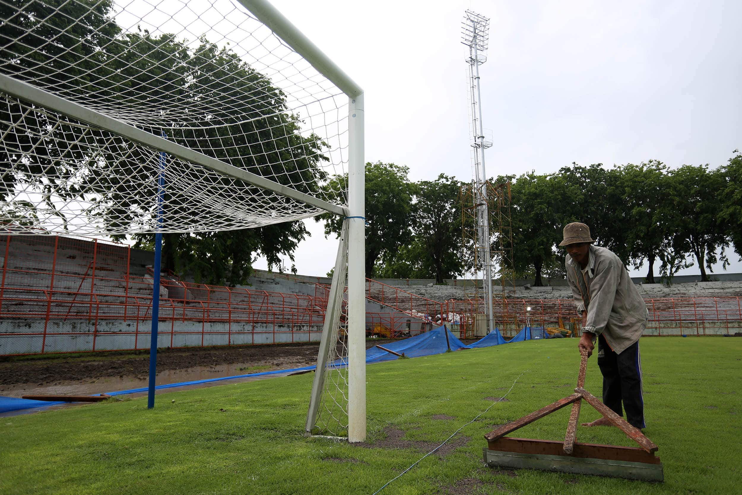 PASANG; Sejumlah menyelesaikan pengerjaan lapangan di Gelora 10 November, Jalan Tambaksari, Surabaya, Kamis (10/12/2020). Intalasi penerangan tersebut mulai dipasang. Lapangan tersebut direnovasi dalam rangka mempersiapkan pertandingan piala dunia u-20 me - Image