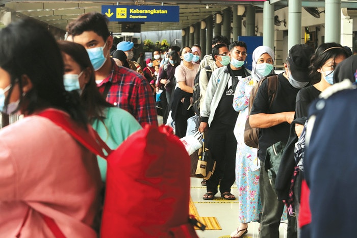 KE LUAR KOTA: Penumpang antre memasuki area peron di Stasiun Pasar Senen, Jakarta, kemarin (26/12). PT KAI telah menjual 428.000 tiket untuk periode libur Natal dan Tahun Baru 2021. (SALMAN TOYIBI/JAWA POS) - Image