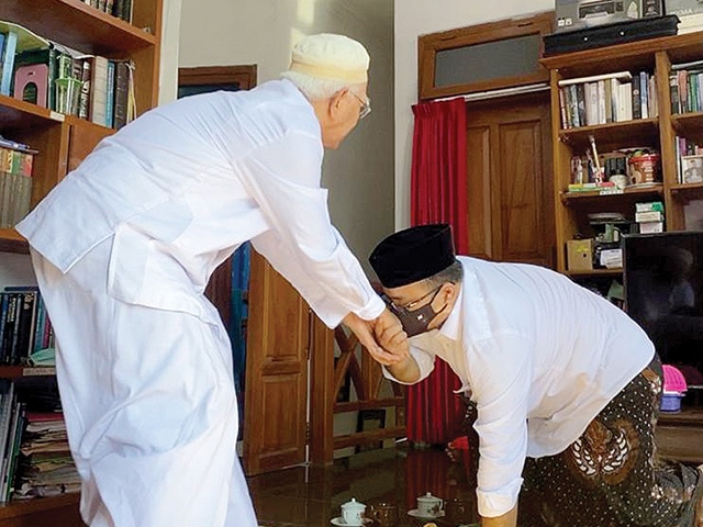 SOWAN PAKLIK: Menteri Agama Yaqut mencium tangan Gus Mus saat berkunjung ke Pondok Pesantren Roudhlotut Tholibin, Leteh, Rembang, Jumat (25/12). (Ponpes Roudhlotut Tholibin for Jawa Pos) - Image