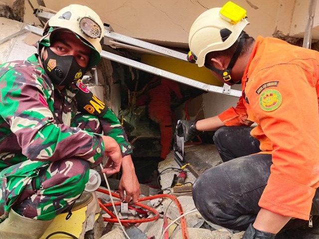Tim Basarnas Kabupaten Mamuju mengevakuasi korban yang masih berada di reruntuhan bangunan yang rubuh. Mamuju dilanda gempa berkekuatan 6,2 magnitudo. (HO/Basarnas Mamuju/ANTARA) - Image