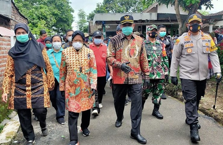 Menteri sosial Tri Rismaharini didampingi Bupati Mojokerto Pungkasiadi (dua kanan) dan Kapolres Mojokerto AKBP Donny Alexander melakukan kunjungan ke Sumberglagah, Kota Mojokerto, Jawa Timur, Sabtu (2/1/2021). ANTARA/Indra Setiawan/aa. - Image