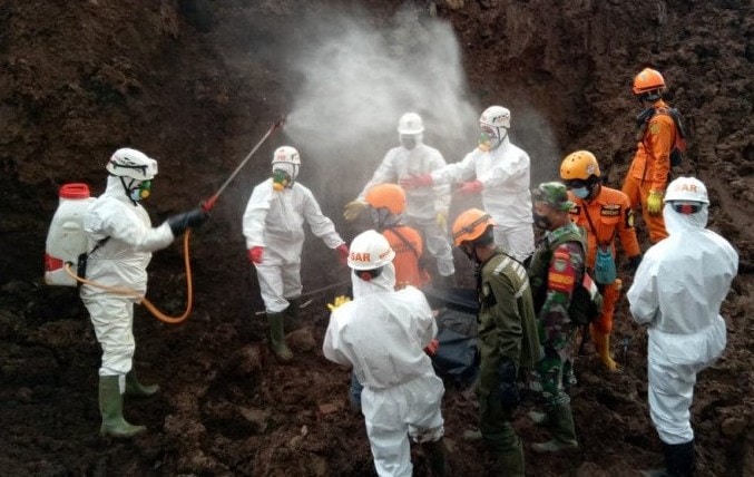Petugas menyemprotkan cairan disinfektan ketika melakukan evakuasi korban longsor di Kecamatan Cimanggung, Kabupaten Sumedang, Jawa Barat, Sabtu (16/1). Kantor SAR Bandung/Antara - Image
