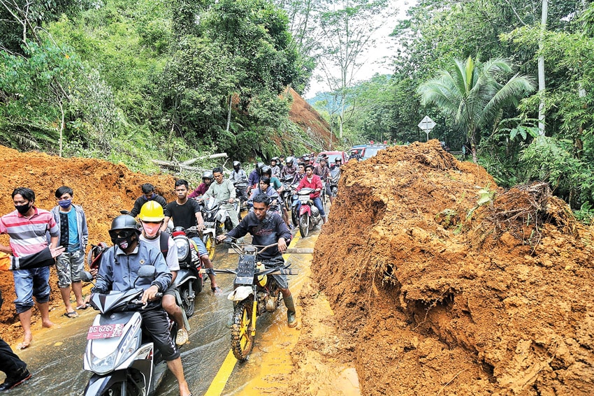 DAMPAK GEMPA: Pengendara berusaa menerobos jalan trans-Sulawesi yang terimbun longsor di Desa Takandaeng, Kecamatan Tapalang, Kabupaten Mamuju, Sulbar, kemarin (16/1). (IDHAM AMA/FAJAR) - Image