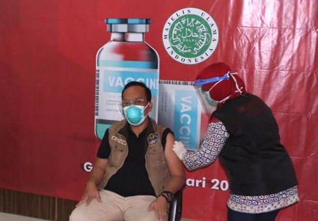 AMAN DAN HALAL: Kepala Dinkes Pemkab Gresik drg Syaifuddin Ghozali mendapat suntikan vaksin pertama pada Jumat lalu (15/1). (Galih Wicaksono/Jawa Pos) - Image