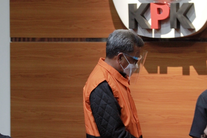 Gubernur Sulawesi Selatan Nurdin Abdullah mengenakan rompi tahanan usai menjalani pemeriksaan di gedung KPK, Jakarta, Minggu (28/2/2021) dini hari. KPK menetapkan tiga orang tersangka dalam Operasi Tangkap Tangan (OTT) terkait kasus dugaan suap proyek inf - Image