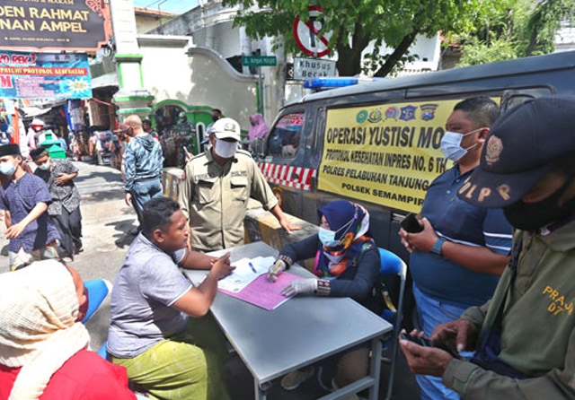 DIDATA: PEtugas mencatat identitas pelanggar prokes di Wisata Religi Ampel, Minggu (31/1). (Ahmad Khusaini/Jawa Pos) - Image