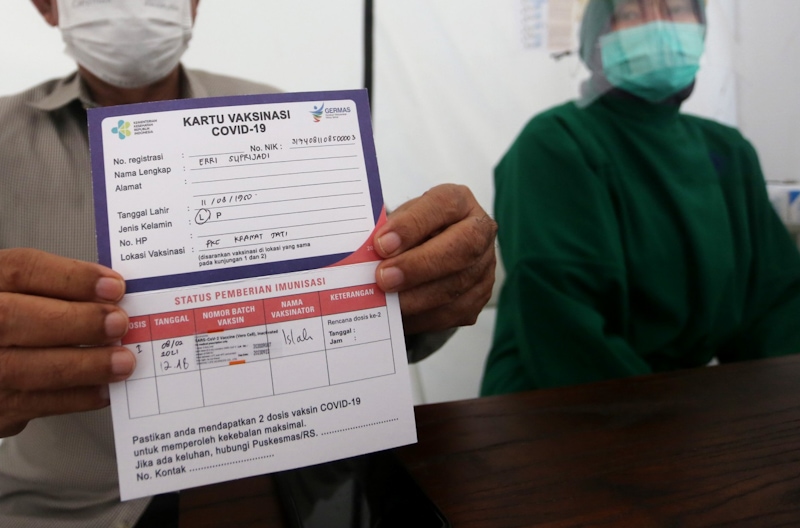Tenaga kesehatan berusia lanjut menunjukan kartu usai mendapakan vaksinasi Covid-19 di Puskesmas Kramat Jati, Jakarta, Senin (8/2/2021). Kementerian Kesehatan (Kemenkes) memulai melakukan vaksinasi tenaga kesehatan di atas usia 60 tahun setelah Badan Peng - Image