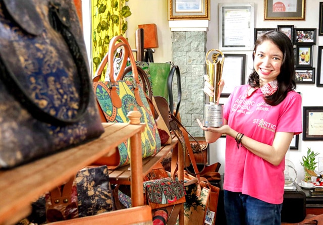 PENCINTA LINGKUNGAN: Vania Santoso menunjukkan award di depan karyakaryanya yang memanfaatkan barang tak terpakai. (NURUL KOMARIYAH/JAWA POS) - Image