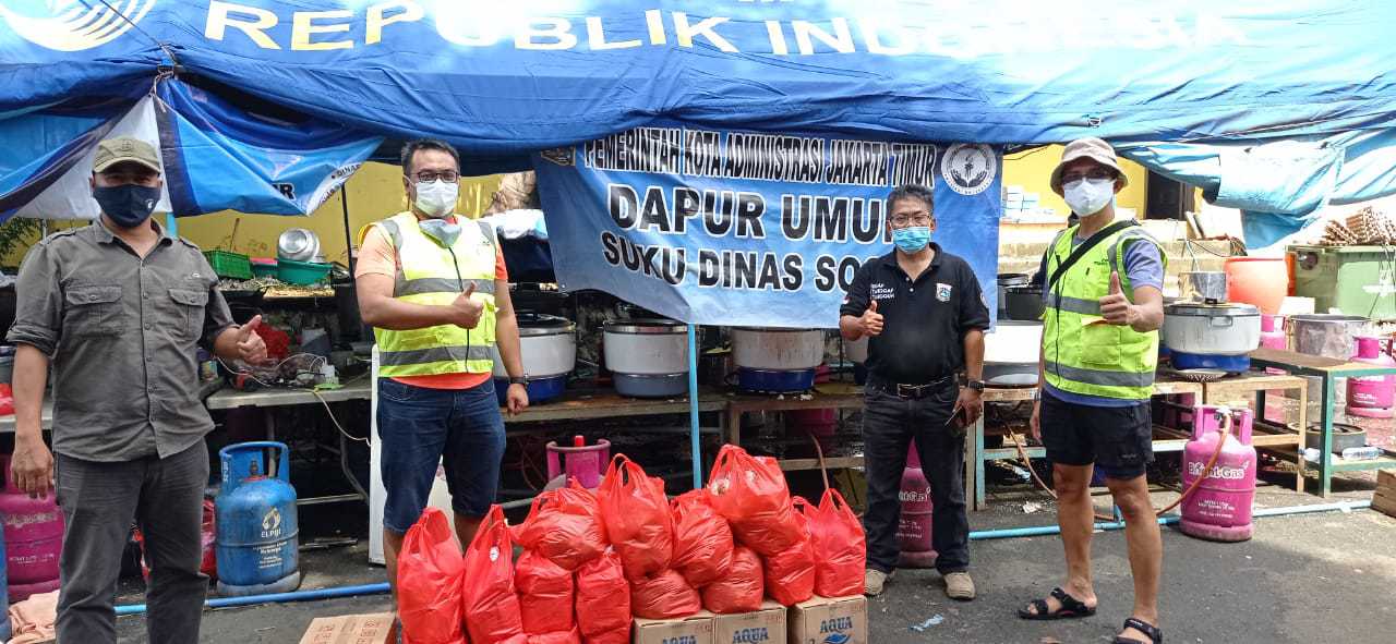 Tim CSR Bank Mandiri saat menyerahkan bantuan paket nasi bungkus kepada Kasudinsos Jakarta Timur Purwono (dua kanan), di posko bantuan Kampung Melayu, Jakarta, Minggu (21/2). (BANK MANDIRI FOR JAWAPOS.COM) - Image